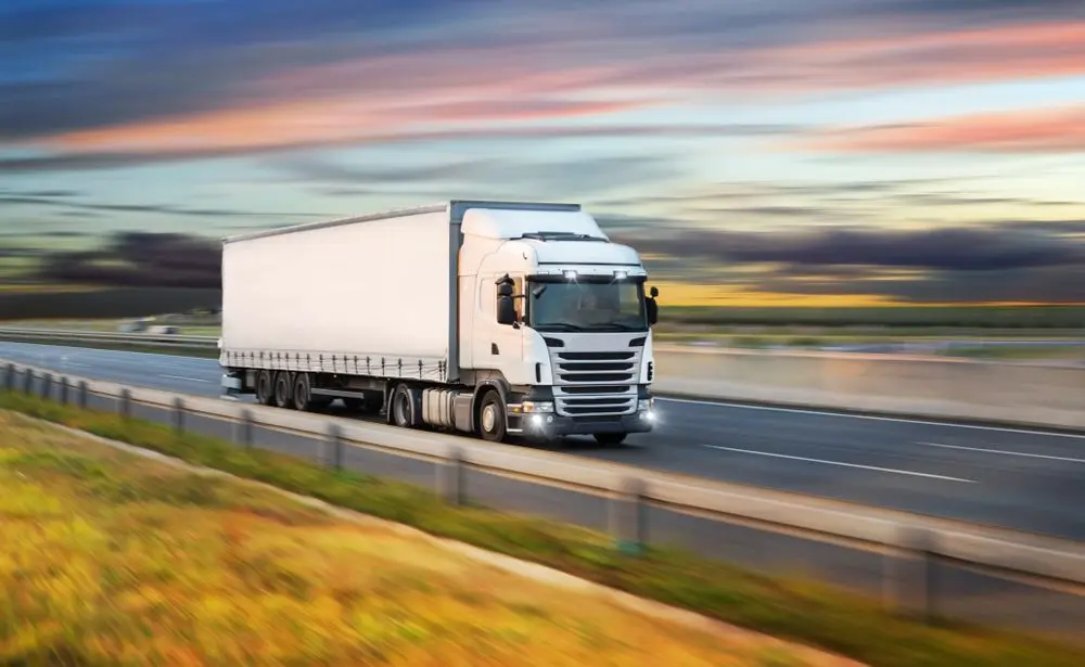 Truck driving on a highway illustrating road transport operations.