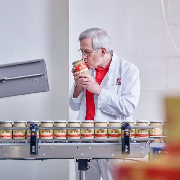 Man inspecting a jar on a food production line